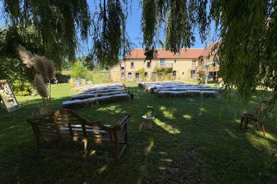 Cuisine ouverte avec plan de travail en bois, armoires vertes, éclairage au plafond et poutres apparentes.