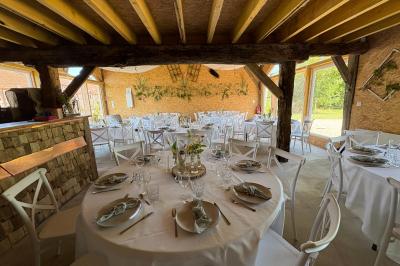 Cuisine ouverte avec plan de travail en bois, armoires vertes, éclairage au plafond et poutres apparentes.