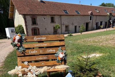 Cuisine ouverte avec plan de travail en bois, armoires vertes, éclairage au plafond et poutres apparentes.