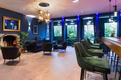 Toilettes accessibles avec barre d'appui, lavabo mural et distributeur de savon dans un espace sombre.