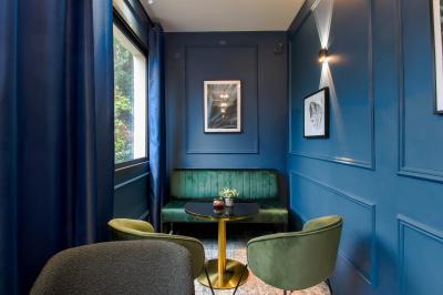 Toilettes accessibles avec barre d'appui, lavabo mural et distributeur de savon dans un espace sombre.