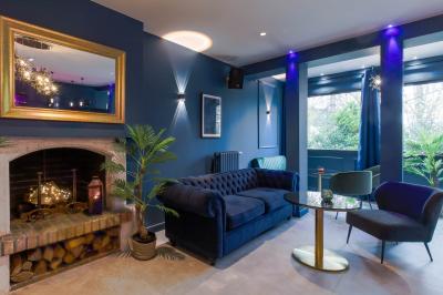 Toilettes accessibles avec barre d'appui, lavabo mural et distributeur de savon dans un espace sombre.