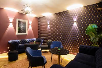 Toilettes accessibles avec barre d'appui, lavabo mural et distributeur de savon dans un espace sombre.