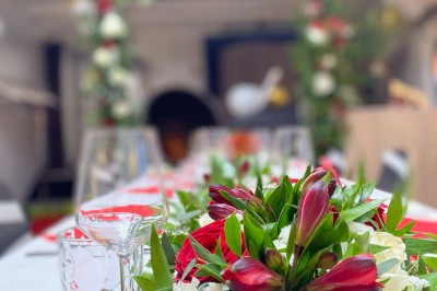 Intérieur lumineux d'un bureau aménagé dans une péniche, avec mobilier moderne, murs blancs et sol rouge.