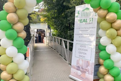 Intérieur lumineux d'un bureau aménagé dans une péniche, avec mobilier moderne, murs blancs et sol rouge.