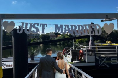 Intérieur lumineux d'un bureau aménagé dans une péniche, avec mobilier moderne, murs blancs et sol rouge.