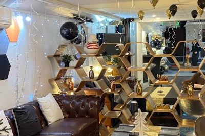 Intérieur lumineux d'un bureau aménagé dans une péniche, avec mobilier moderne, murs blancs et sol rouge.