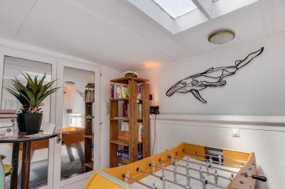 Cuisine professionnelle avec réfrigérateur en inox, four, hotte, étagères murales et plan de travail en acier inoxydable.