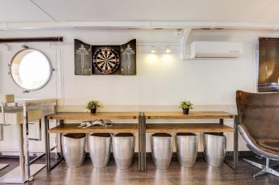 Cuisine professionnelle avec réfrigérateur en inox, four, hotte, étagères murales et plan de travail en acier inoxydable.