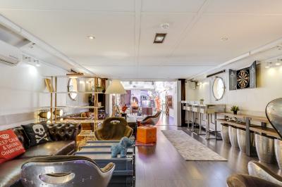 Cuisine professionnelle avec réfrigérateur en inox, four, hotte, étagères murales et plan de travail en acier inoxydable.