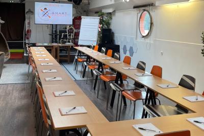 Cuisine professionnelle avec réfrigérateur en inox, four, hotte, étagères murales et plan de travail en acier inoxydable.