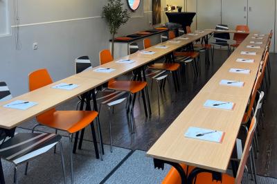 Cuisine professionnelle avec réfrigérateur en inox, four, hotte, étagères murales et plan de travail en acier inoxydable.