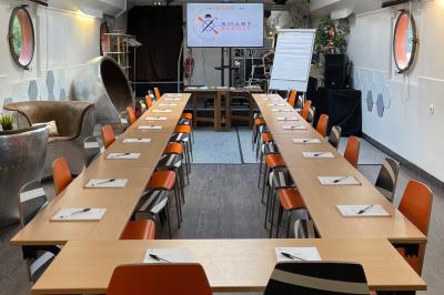 Cuisine professionnelle avec réfrigérateur en inox, four, hotte, étagères murales et plan de travail en acier inoxydable.