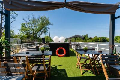 Cuisine professionnelle avec réfrigérateur en inox, four, hotte, étagères murales et plan de travail en acier inoxydable.