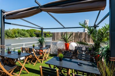 Cuisine professionnelle avec réfrigérateur en inox, four, hotte, étagères murales et plan de travail en acier inoxydable.