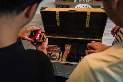 Une personne lit un manga ’Dragon Ball’ avec une couverture bleue illustrée de personnages.