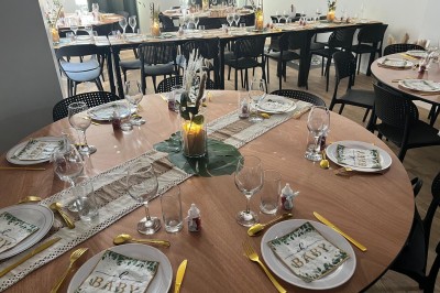 Table dressée avec élégance, comprenant des verres, une assiette décorée ’oh baby’, des couverts dorés et des éléments…