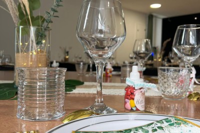Table dressée avec élégance, comprenant des verres, une assiette décorée ’oh baby’, des couverts dorés et des éléments…
