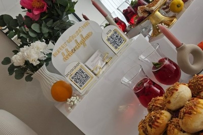 Buffet décoré avec des fleurs, fruits frais, verrines, mini-burgers et desserts, présenté sur une table élégante.