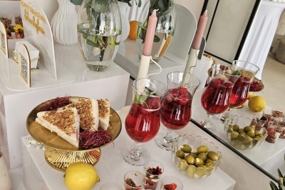 Buffet décoré avec des fleurs, fruits frais, verrines, mini-burgers et desserts, présenté sur une table élégante.