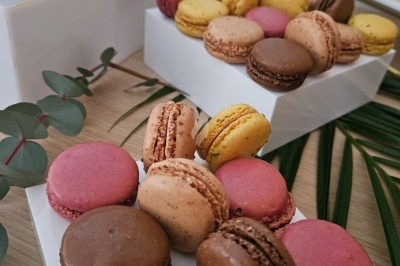 Buffet décoré avec des fleurs, fruits frais, verrines, mini-burgers et desserts, présenté sur une table élégante.