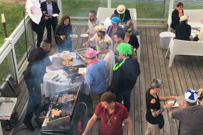 Façade éclairée d'un bâtiment nommé ’Le Yacht’ de nuit, avec des lumières bleues et un espace extérieur aménagé.