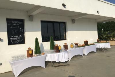 Façade éclairée d'un bâtiment nommé ’Le Yacht’ de nuit, avec des lumières bleues et un espace extérieur aménagé.