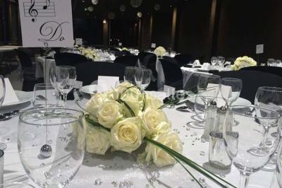 Façade éclairée d'un bâtiment nommé ’Le Yacht’ de nuit, avec des lumières bleues et un espace extérieur aménagé.