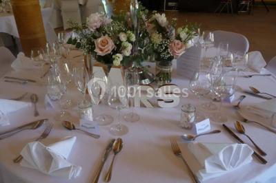 Façade éclairée d'un bâtiment nommé ’Le Yacht’ de nuit, avec des lumières bleues et un espace extérieur aménagé.