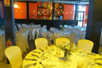 Façade éclairée d'un bâtiment nommé ’Le Yacht’ de nuit, avec des lumières bleues et un espace extérieur aménagé.