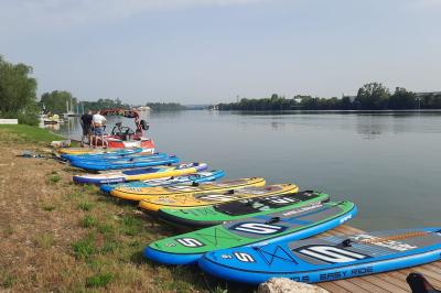 Façade éclairée d'un bâtiment nommé ’Le Yacht’ de nuit, avec des lumières bleues et un espace extérieur aménagé.