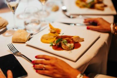 Éoliennes dans un paysage rural avec des vignes au premier plan et un ciel nuageux en arrière-plan.