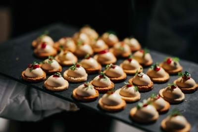 Éoliennes dans un paysage rural avec des vignes au premier plan et un ciel nuageux en arrière-plan.