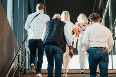 Éoliennes dans un paysage rural avec des vignes au premier plan et un ciel nuageux en arrière-plan.