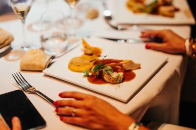 Éoliennes dans un paysage rural avec des vignes au premier plan et un ciel nuageux en arrière-plan.