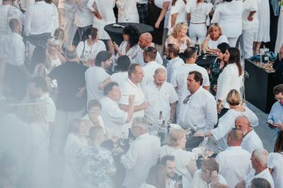 Rangées de chaises noires alignées dans une salle lumineuse avec une table en bois au premier plan.