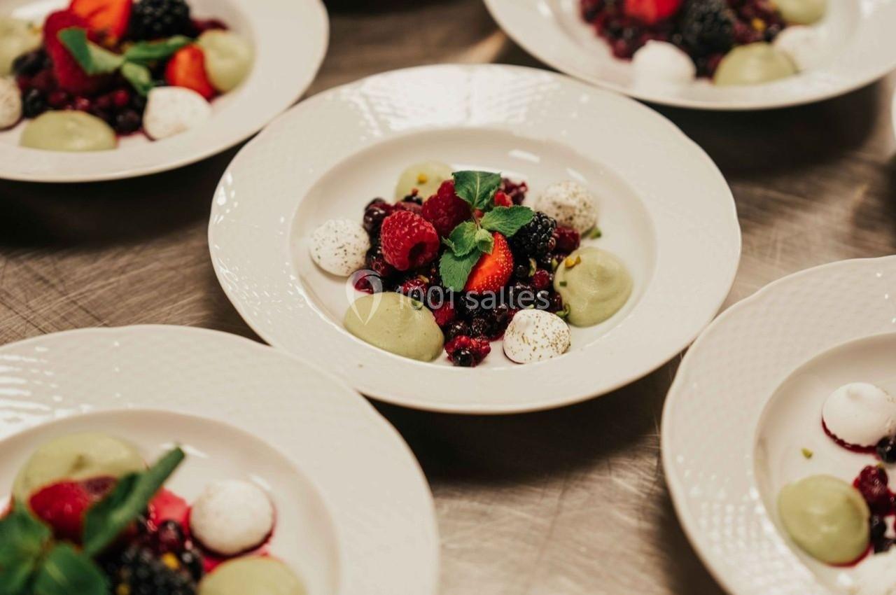 Assiettes de desserts composées de fruits rouges, meringues et crèmes colorées, décorées de feuilles de menthe.