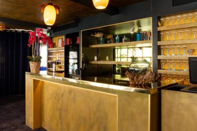 Bâtiment flottant moderne avec façade végétalisée, accessible par une passerelle en bois, amarré le long d'un quai pavé.