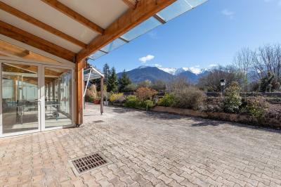 Salle de bain lumineuse avec baignoire, colonnes décoratives, miroir mural et carrelage clair.