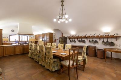 Salle de bain lumineuse avec baignoire, colonnes décoratives, miroir mural et carrelage clair.