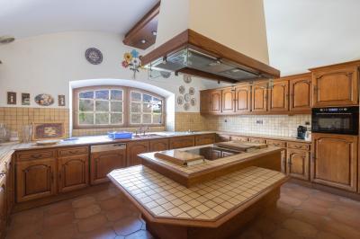 Salle de bain lumineuse avec baignoire, colonnes décoratives, miroir mural et carrelage clair.