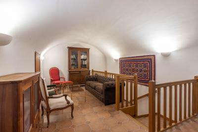 Salle de bain lumineuse avec baignoire, colonnes décoratives, miroir mural et carrelage clair.