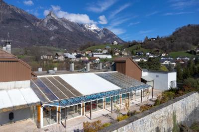 Salle de bain lumineuse avec baignoire, colonnes décoratives, miroir mural et carrelage clair.