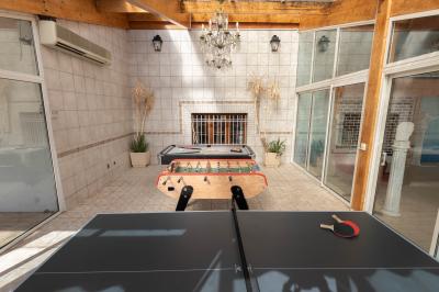 Salle de bain lumineuse avec baignoire, colonnes décoratives, miroir mural et carrelage clair.