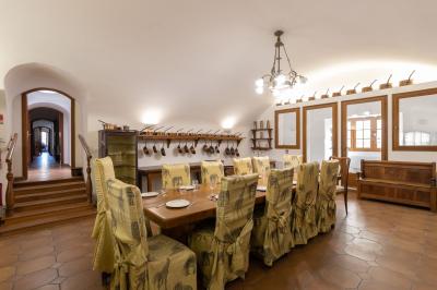 Salle de bain lumineuse avec baignoire, colonnes décoratives, miroir mural et carrelage clair.