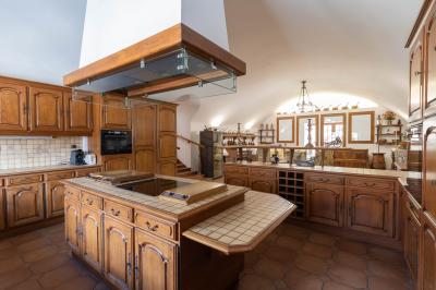 Salle de bain lumineuse avec baignoire, colonnes décoratives, miroir mural et carrelage clair.