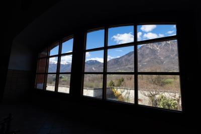 Salle de bain lumineuse avec baignoire, colonnes décoratives, miroir mural et carrelage clair.