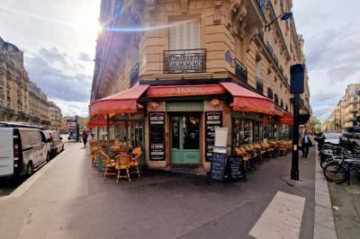 Jarret d'agneau braisé servi sur une purée crémeuse avec des morceaux de carottes, présenté dans une assiette noire.