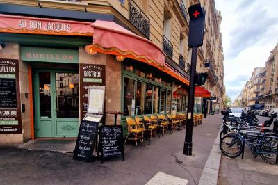 Jarret d'agneau braisé servi sur une purée crémeuse avec des morceaux de carottes, présenté dans une assiette noire.