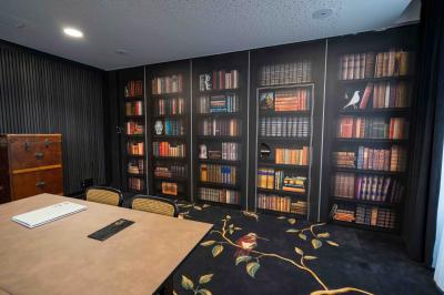 Salle de bain moderne avec toilettes suspendues, sèche-serviettes mural, douche vitrée et murs en carrelage clair.